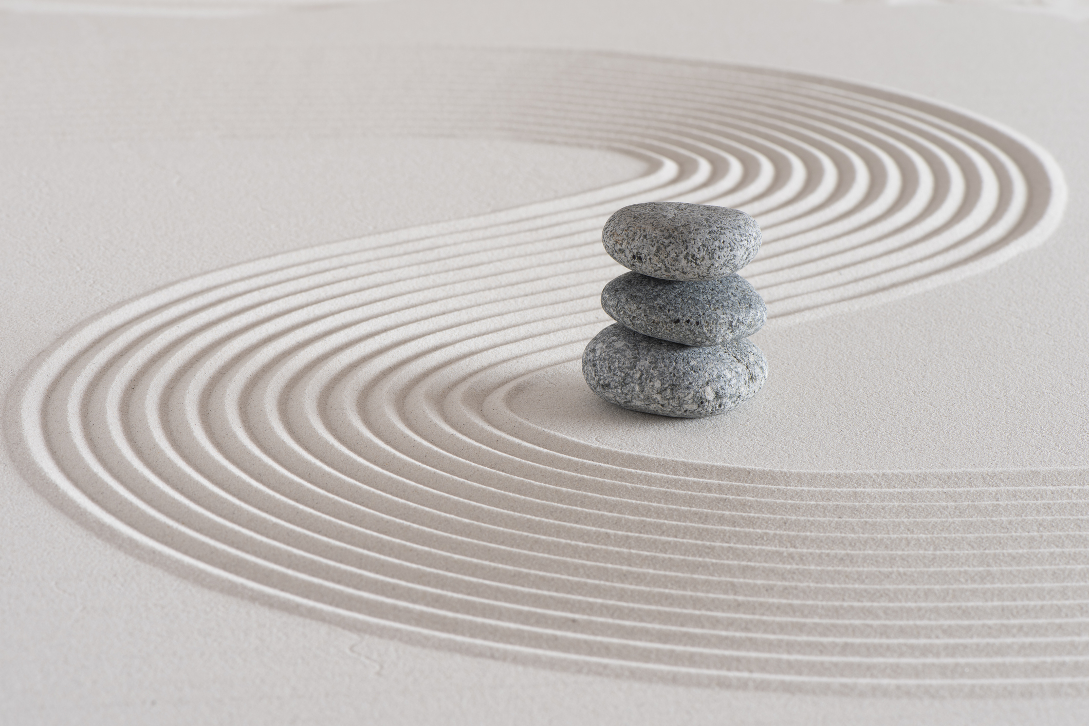 Japanese zen garden with stone in textured white sand